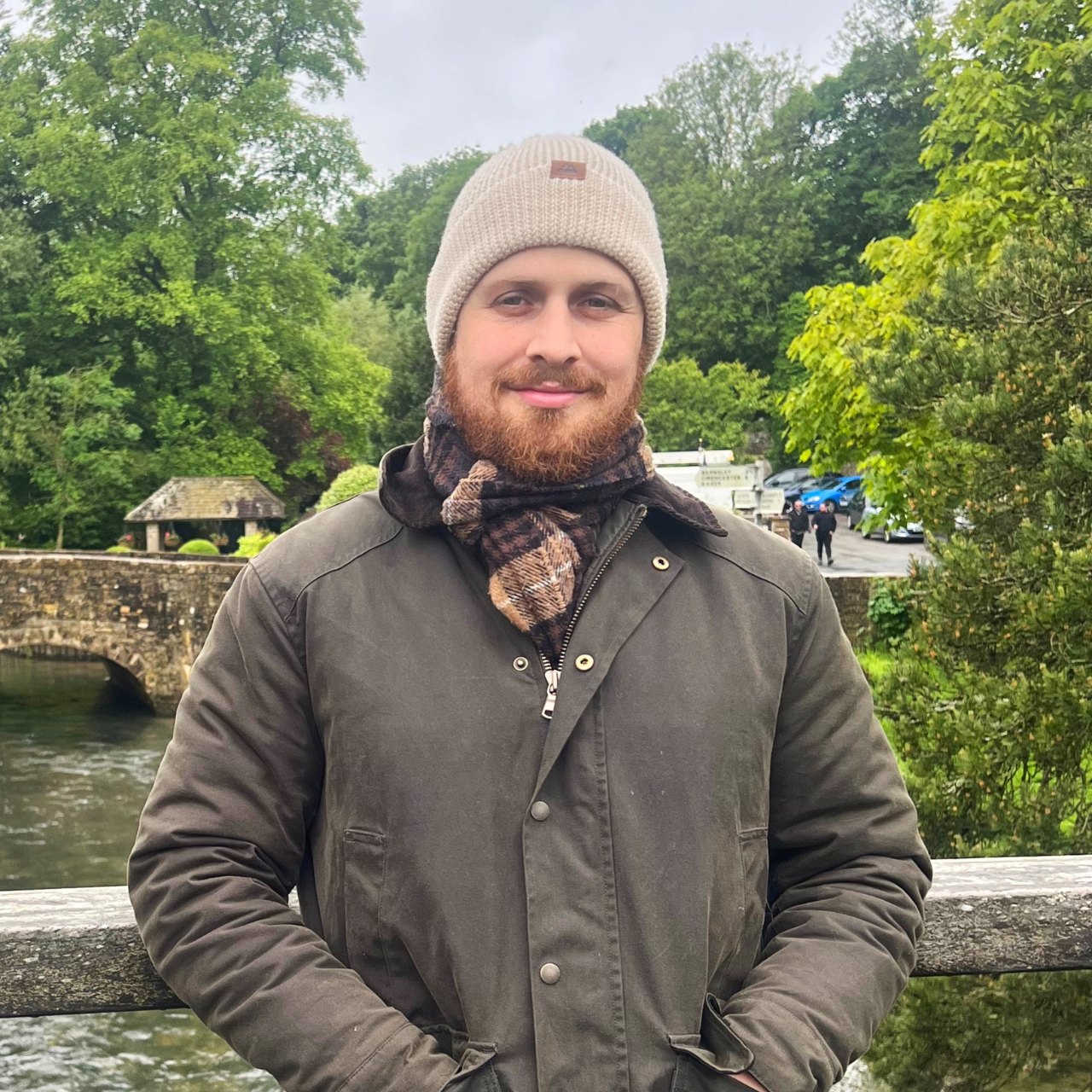 Taz Aldeek smiling on a stone bridge